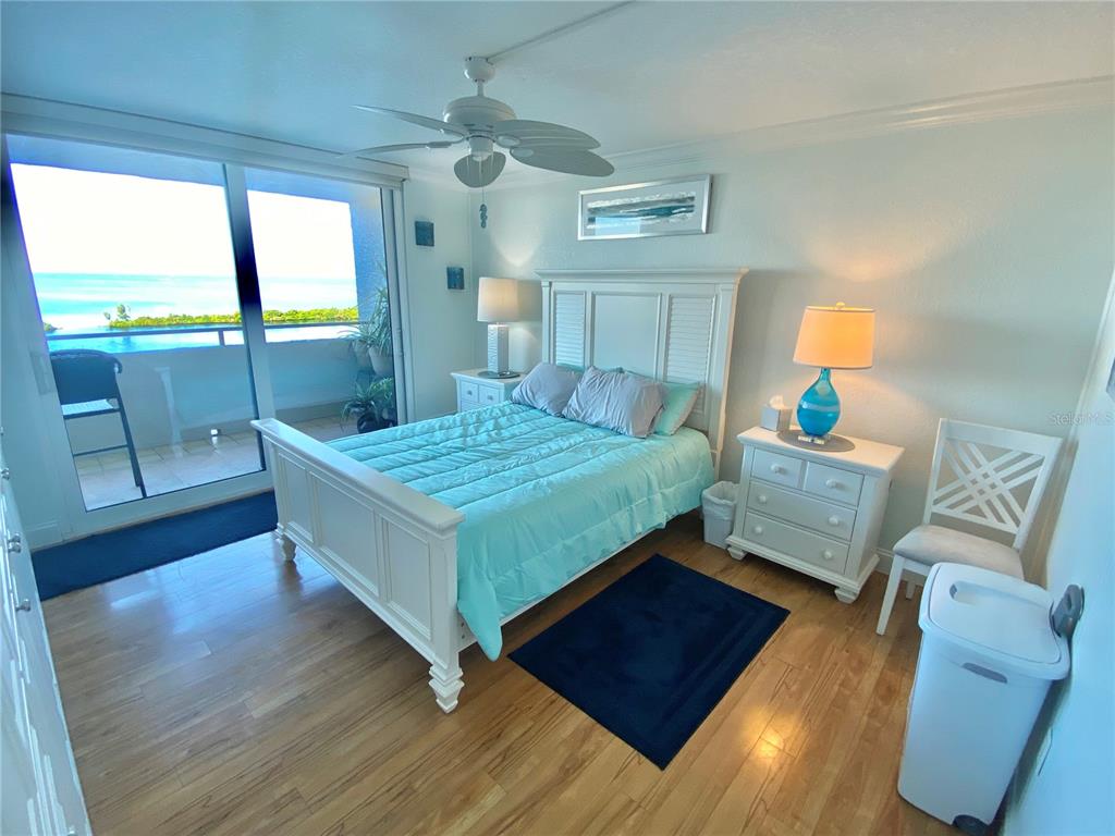 6035 Sea Ranch Drive, Unit 901 Hudson, FL 34667 - Photo 9 of 72 a bedroom with a bed and wooden floor