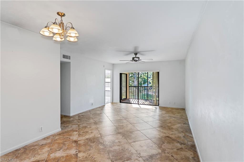 1733 Courtyard Way, Unit 204 Naples, FL 34112 - Photo 3 of 15 Unfurnished room featuring a chandelier and a ceiling fan