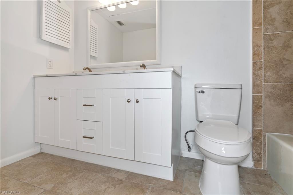 1733 Courtyard Way, Unit 204 Naples, FL 34112 - Photo 6 of 15 Full bathroom featuring toilet and double vanity