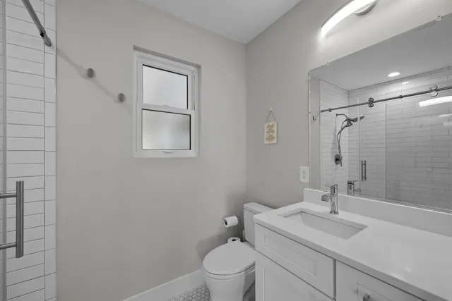 a bathroom with a sink toilet vanity and shower