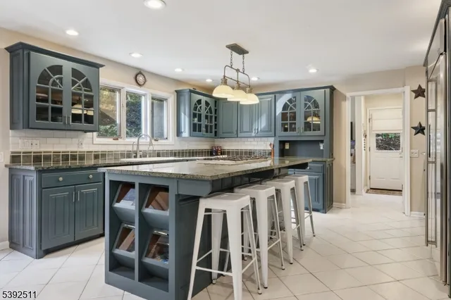 a kitchen with granite countertop a stove a sink and a refrigerator