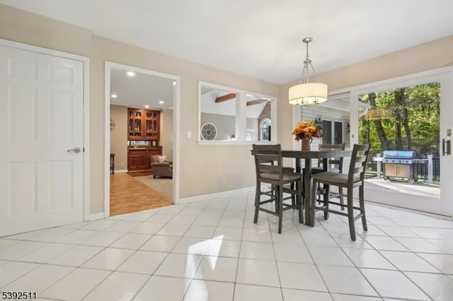 a view of a dining room and livingroom with furniture wooden floor a chandelier