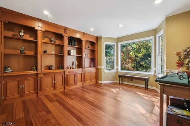 a reading room with wooden floor and furniture