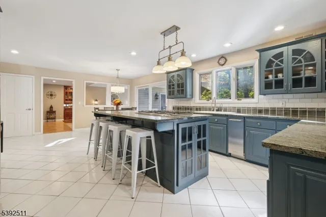 a kitchen with stainless steel appliances granite countertop a stove top oven a sink a counter top space and cabinets