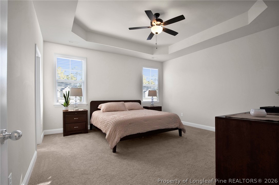 224 Timber Skip Drive Spring Lake, NC 28390 - Photo 13 of 30 a bedroom with a bed and a chandelier