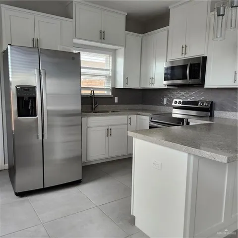 a kitchen with stainless steel appliances a refrigerator sink and microwave