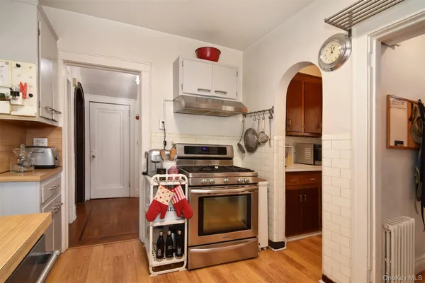 a kitchen with stainless steel appliances granite countertop a stove a refrigerator and a wooden floor