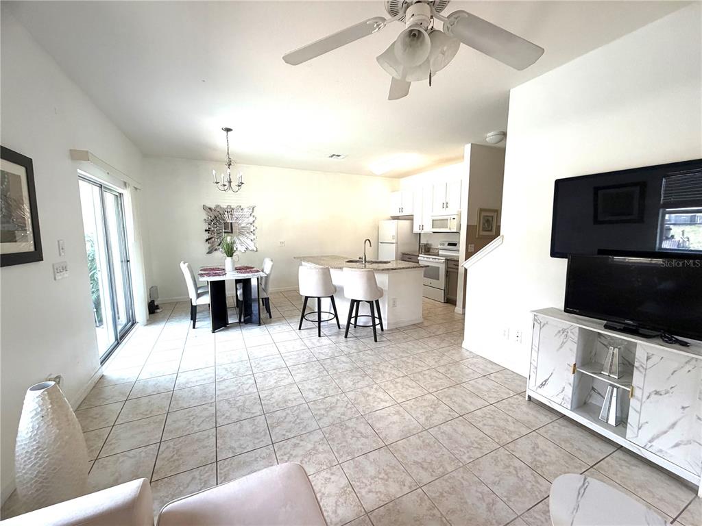 4573 Ada Lane Kissimmee, FL 34746 - Photo 5 of 37 a living room with furniture a dining table and a fireplace