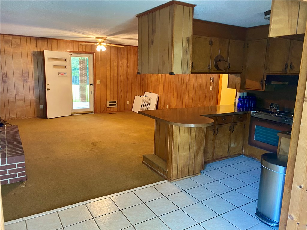 101 Deep Water Point Anderson, SC 29621 - Photo 22 of 34 A classic kitchen with wooden cabinetry and a breakfast bar transitions to a cozy living space.