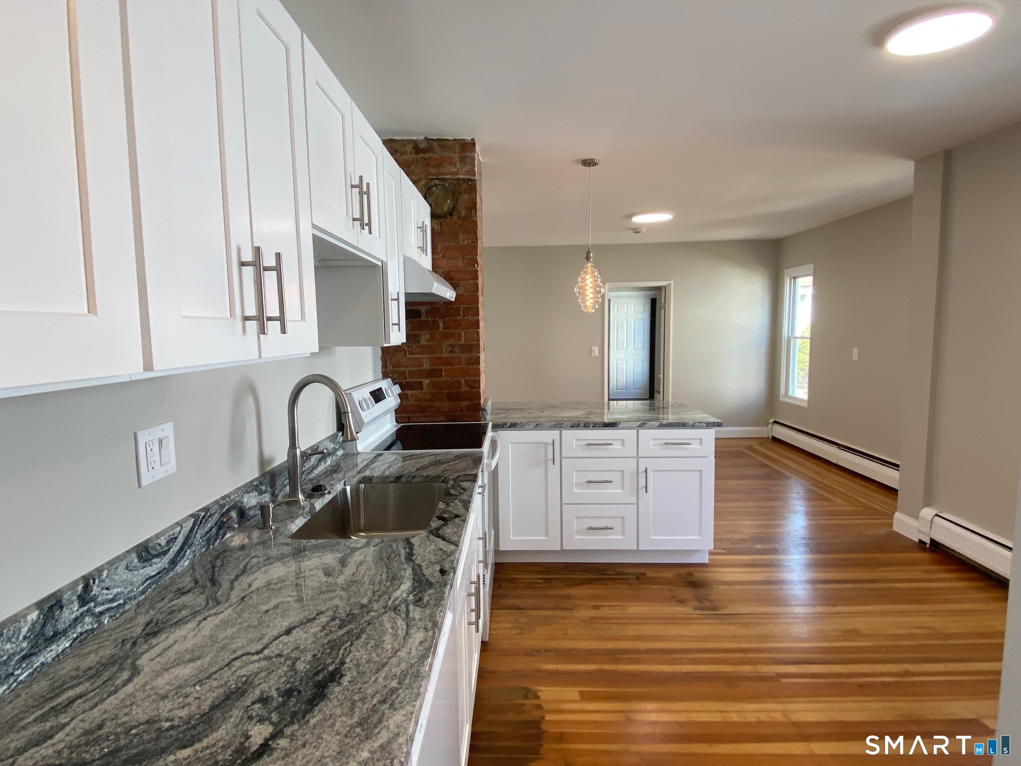 34 Center Street, Unit 2 Bristol, CT 06010 - Photo 2 of 13 a large kitchen with stainless steel appliances granite countertop a granite counter tops and a wooden floors
