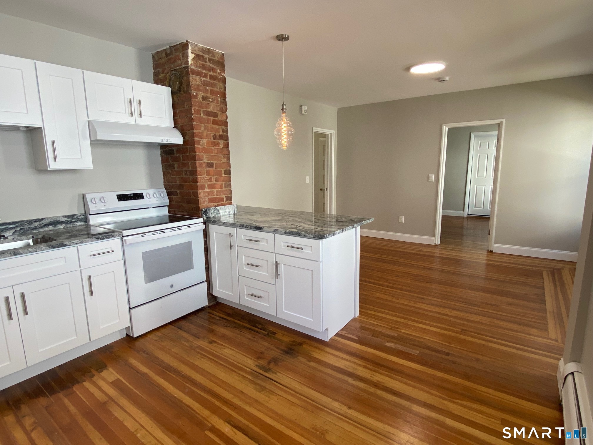 34 Center Street, Unit 2 Bristol, CT 06010 - Photo 4 of 13 a kitchen with stainless steel appliances granite countertop a stove a sink and white cabinets