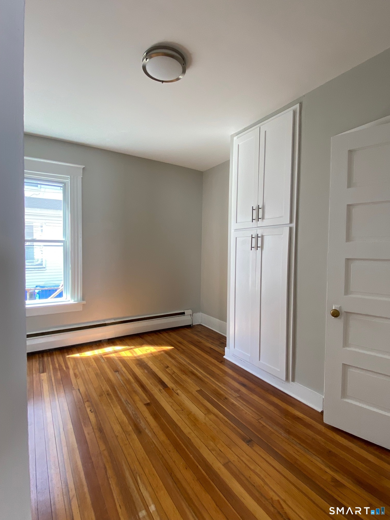 34 Center Street, Unit 2 Bristol, CT 06010 - Photo 10 of 13 a view of an empty room with wooden floor and a window