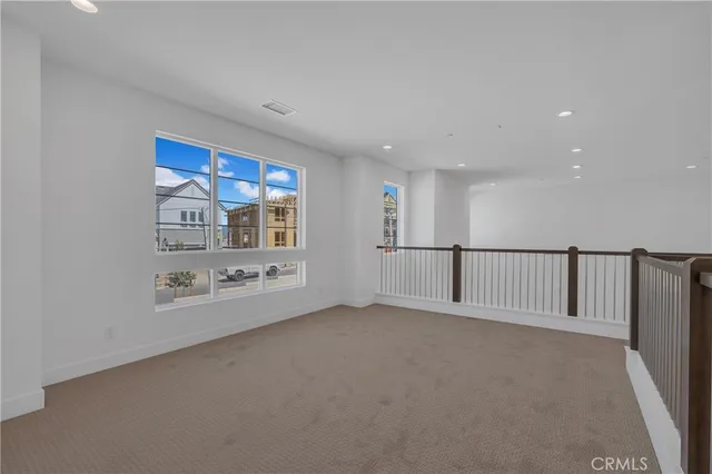 a view of a hallway with wooden floor leading to a staircase