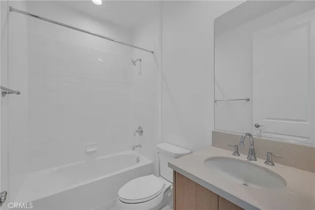 a bathroom with a toilet a sink a mirror and a bathtub