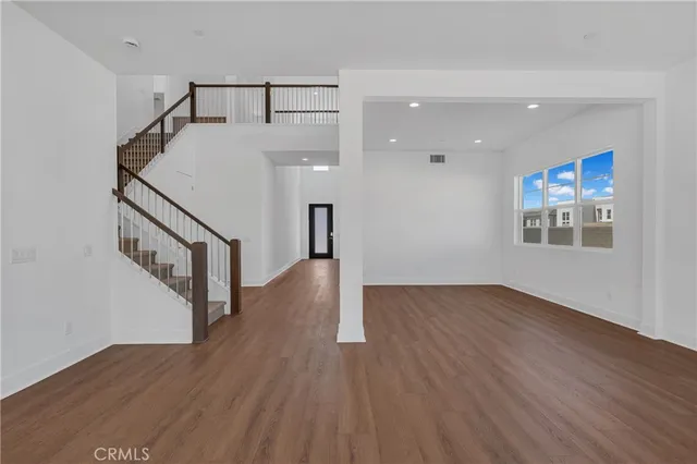 a view of a hallway with wooden floor and stairs