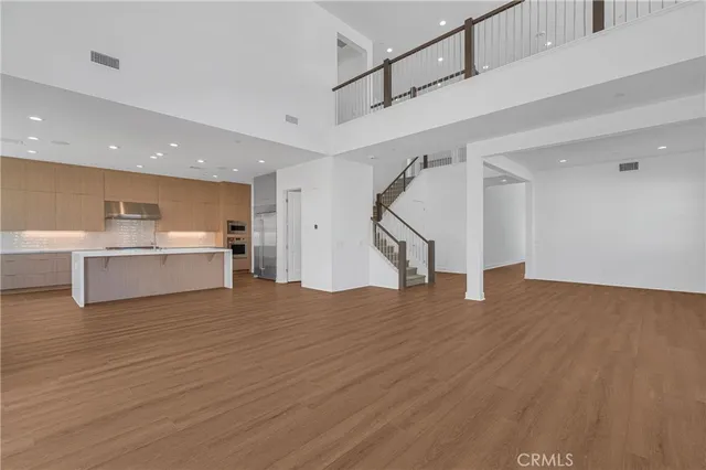a view of a kitchen with wooden floor and stairs