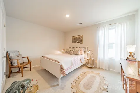 a spacious bedroom with a bed and a chair