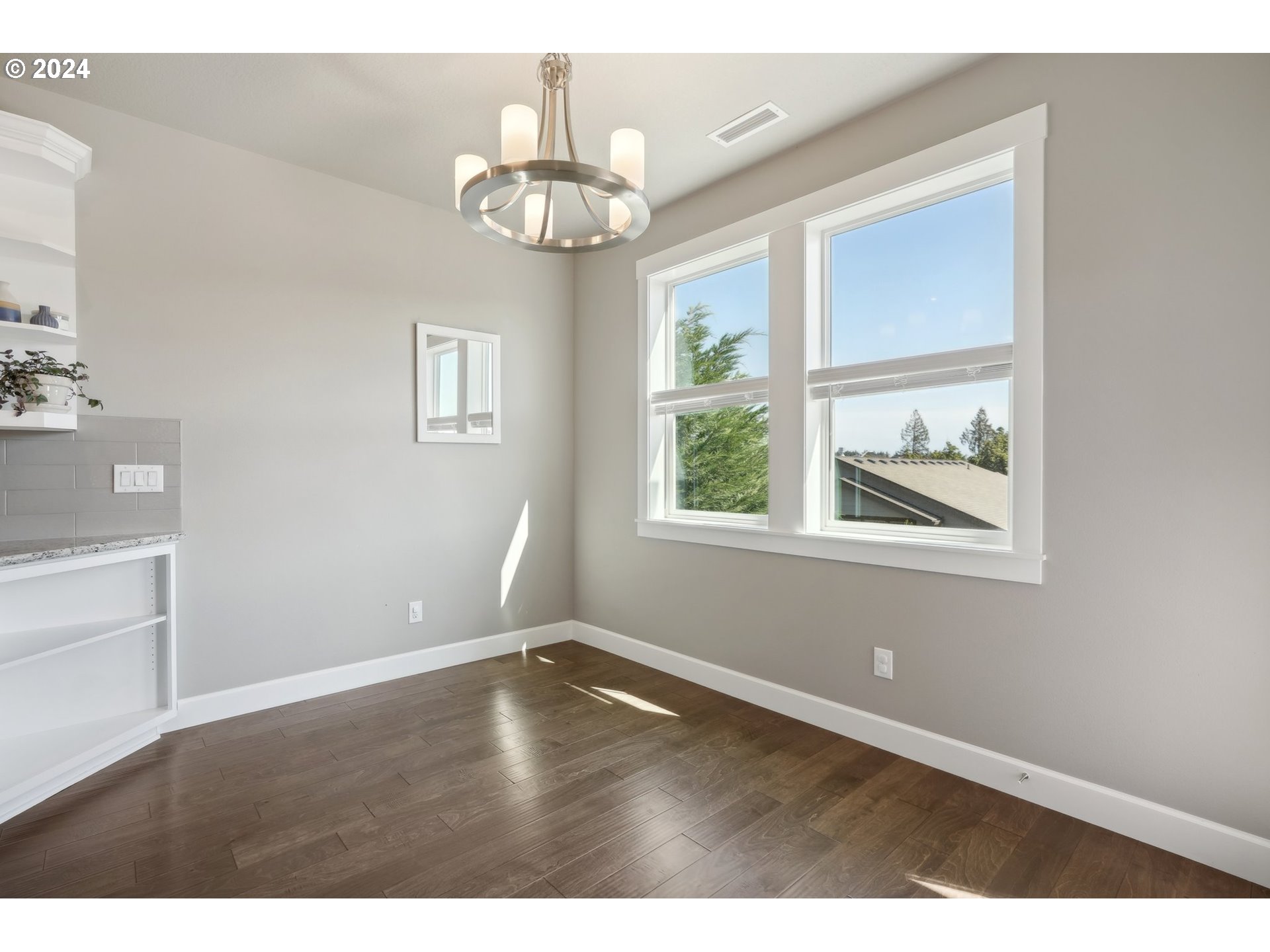 1701 South Nighthawk Road Ridgefield, WA 98642 - Photo 20 of 45 an empty room with wooden floor chandelier and windows