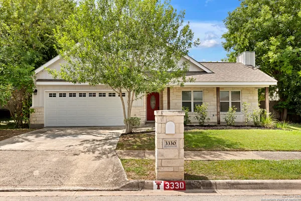 a front view of a house with a garden and tree