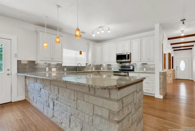 a kitchen with stainless steel appliances granite countertop a stove a sink and a refrigerator