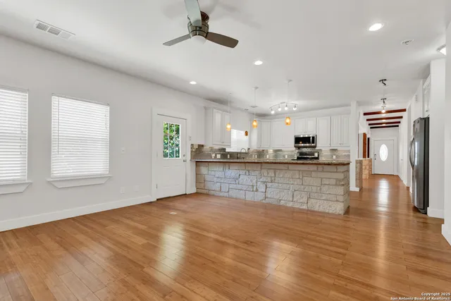 an empty room with wooden floor and windows