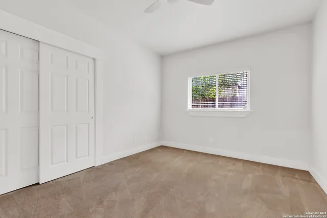 a bathroom with a granite countertop sink a toilet and a mirror