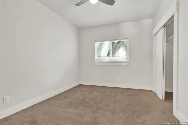 an empty room with windows and closet