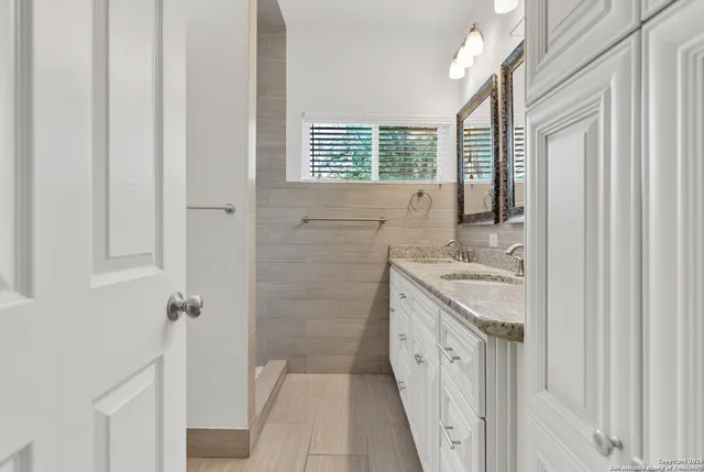 a bathroom with a granite countertop sink and a mirror