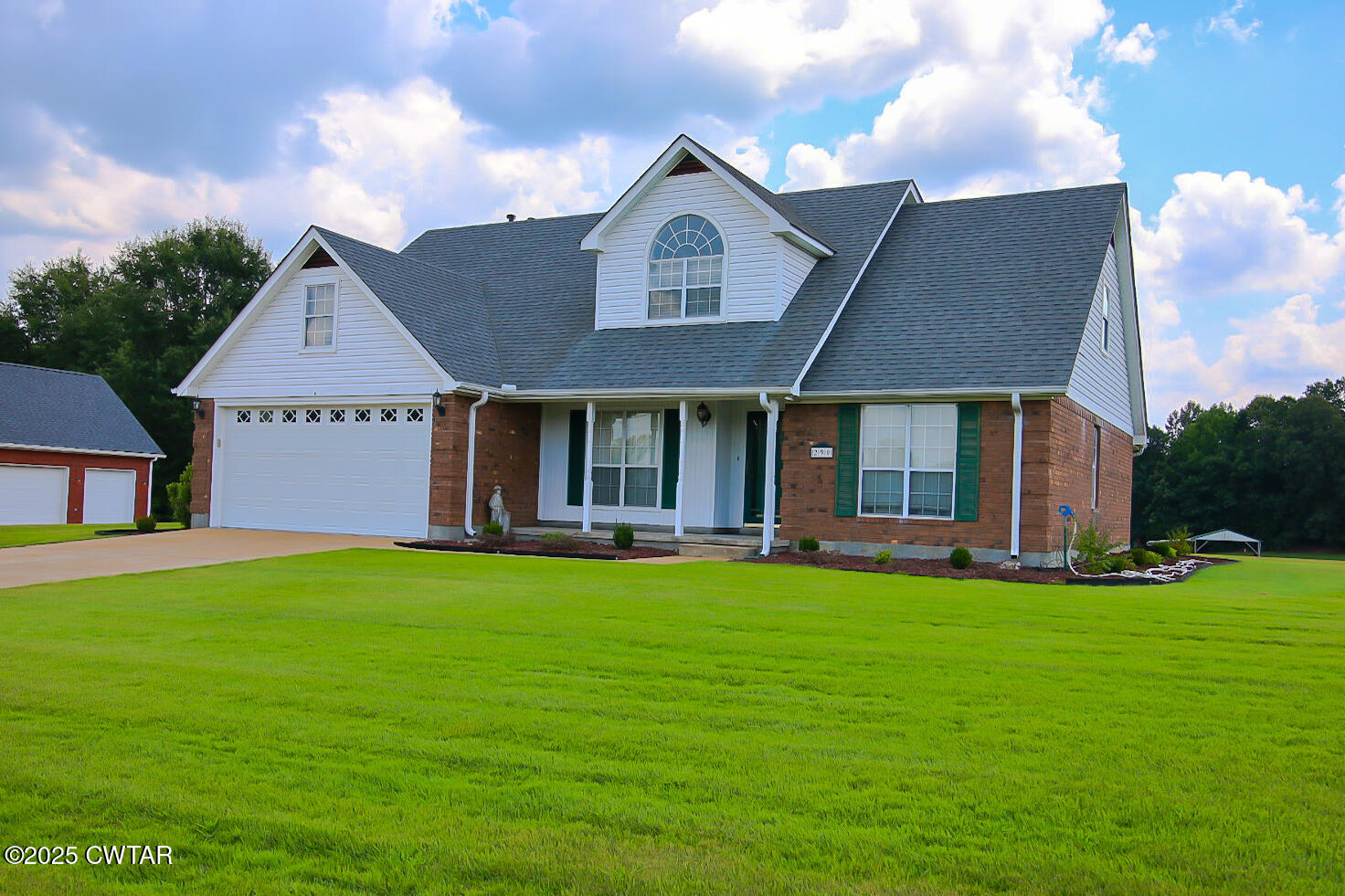 290 Westover Road Huron, TN 38345 - Photo 3 of 26 a front view of a house with a garden and porch