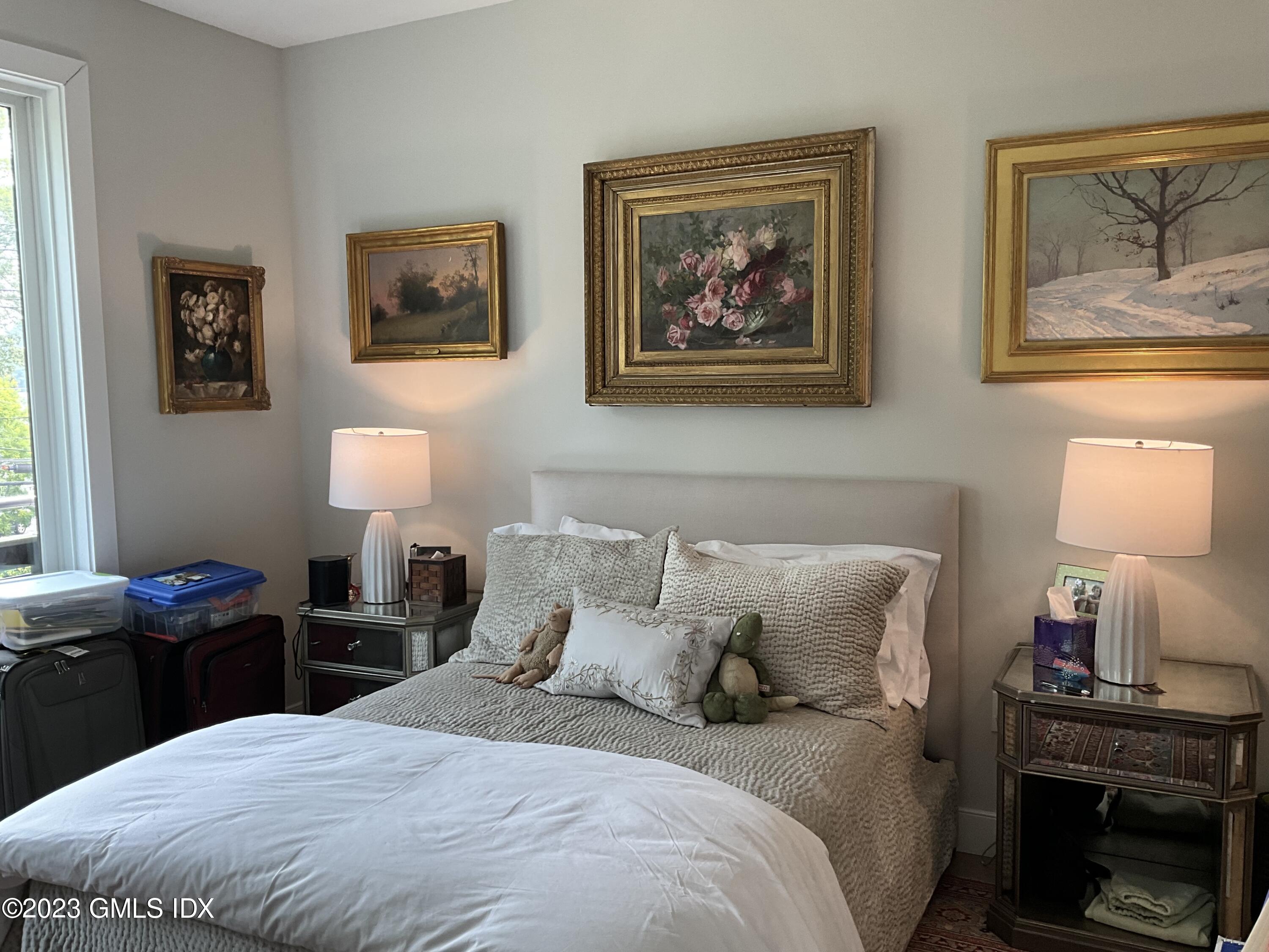 56 Old Field Point Road, Unit 4 Greenwich, CT 06830 - Photo 12 of 32 a bedroom with a bed and a lamp on dresser