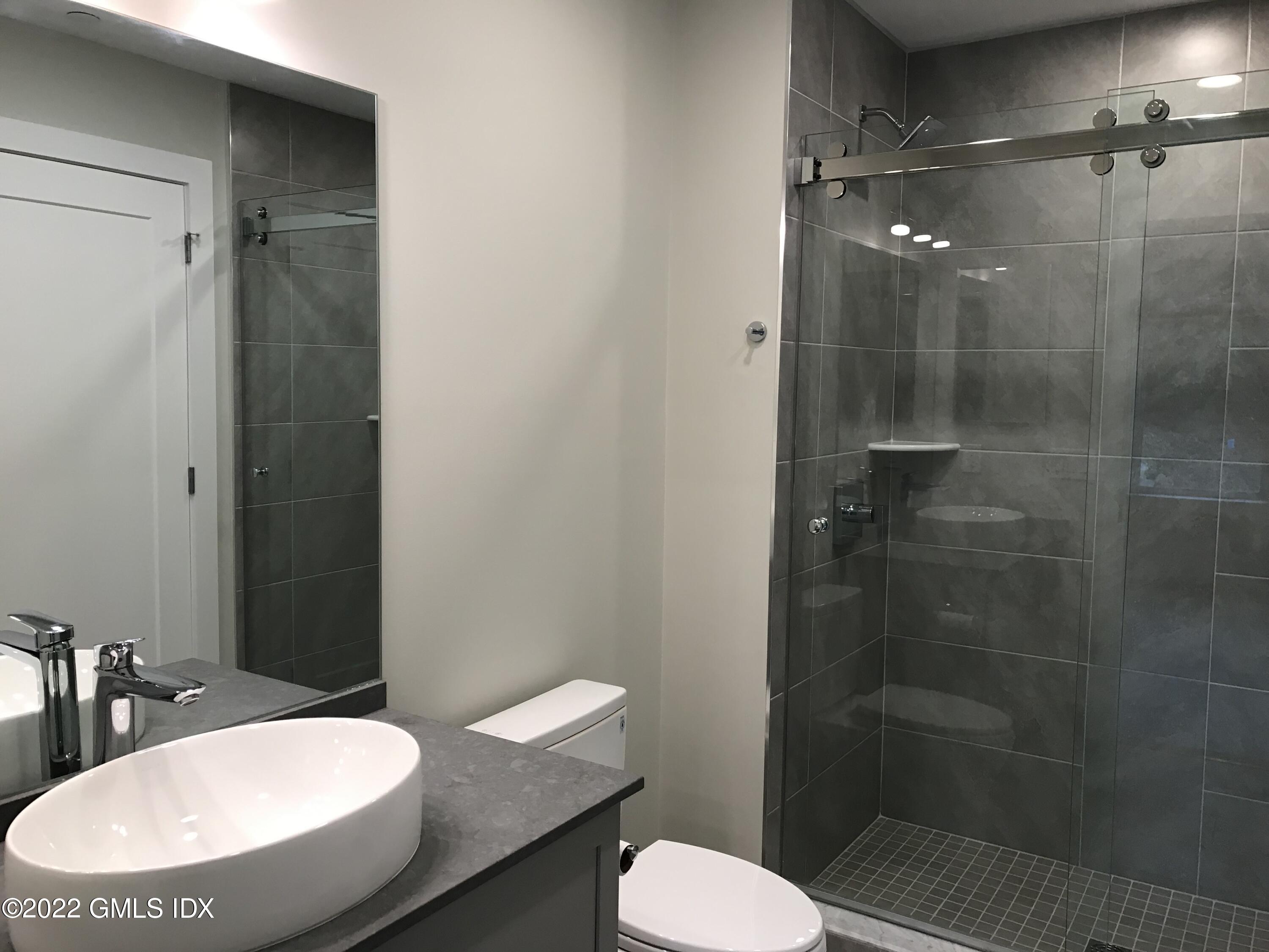 56 Old Field Point Road, Unit 4 Greenwich, CT 06830 - Photo 23 of 32 a bathroom with a sink toilet and shower