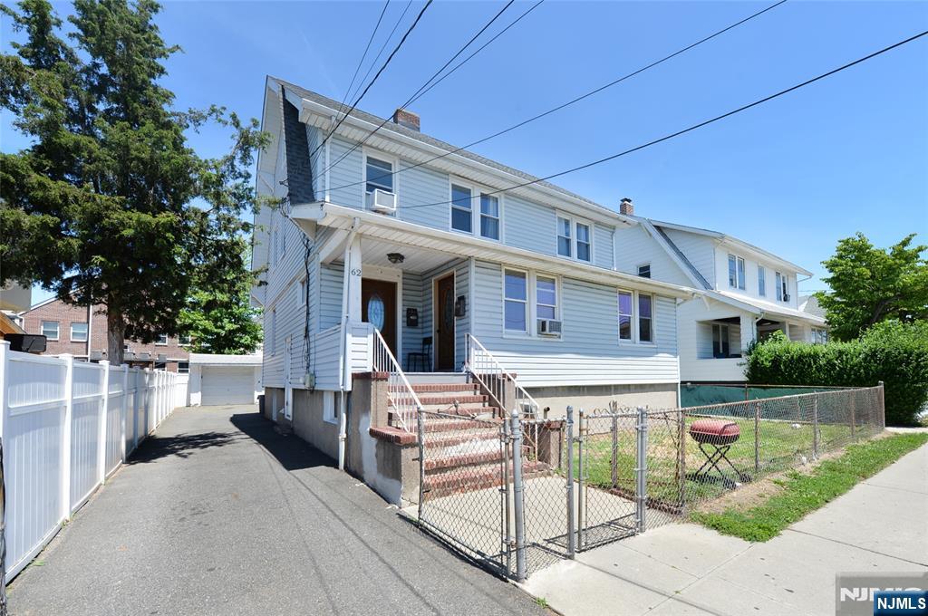 62 Broadway, Unit 1 Hackensack, NJ 07601 - Photo 1 of 25 a view of a white house with a small yard and plants