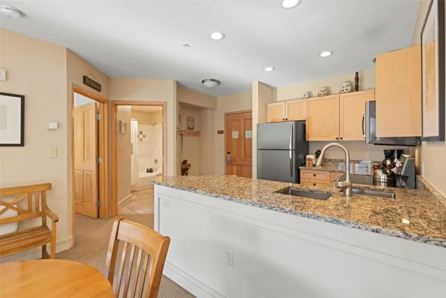 a kitchen with stainless steel appliances granite countertop a refrigerator and a stove