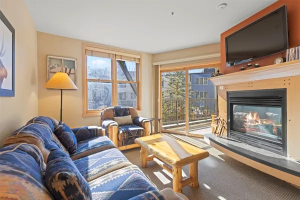 a living room with furniture a flat screen tv and a fireplace