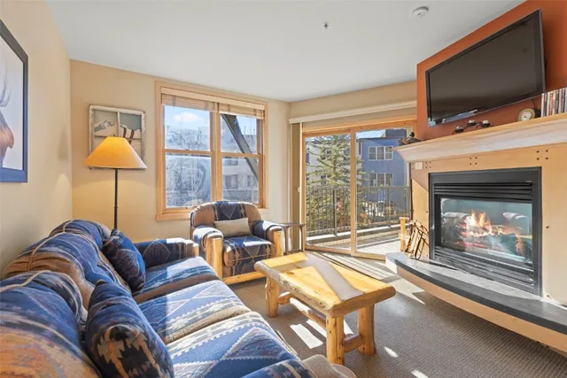 a living room with furniture a flat screen tv and a fireplace