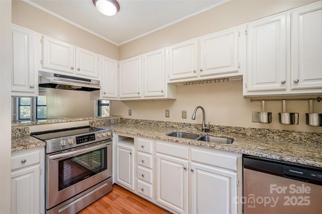 a kitchen with granite countertop a stove sink and cabinets