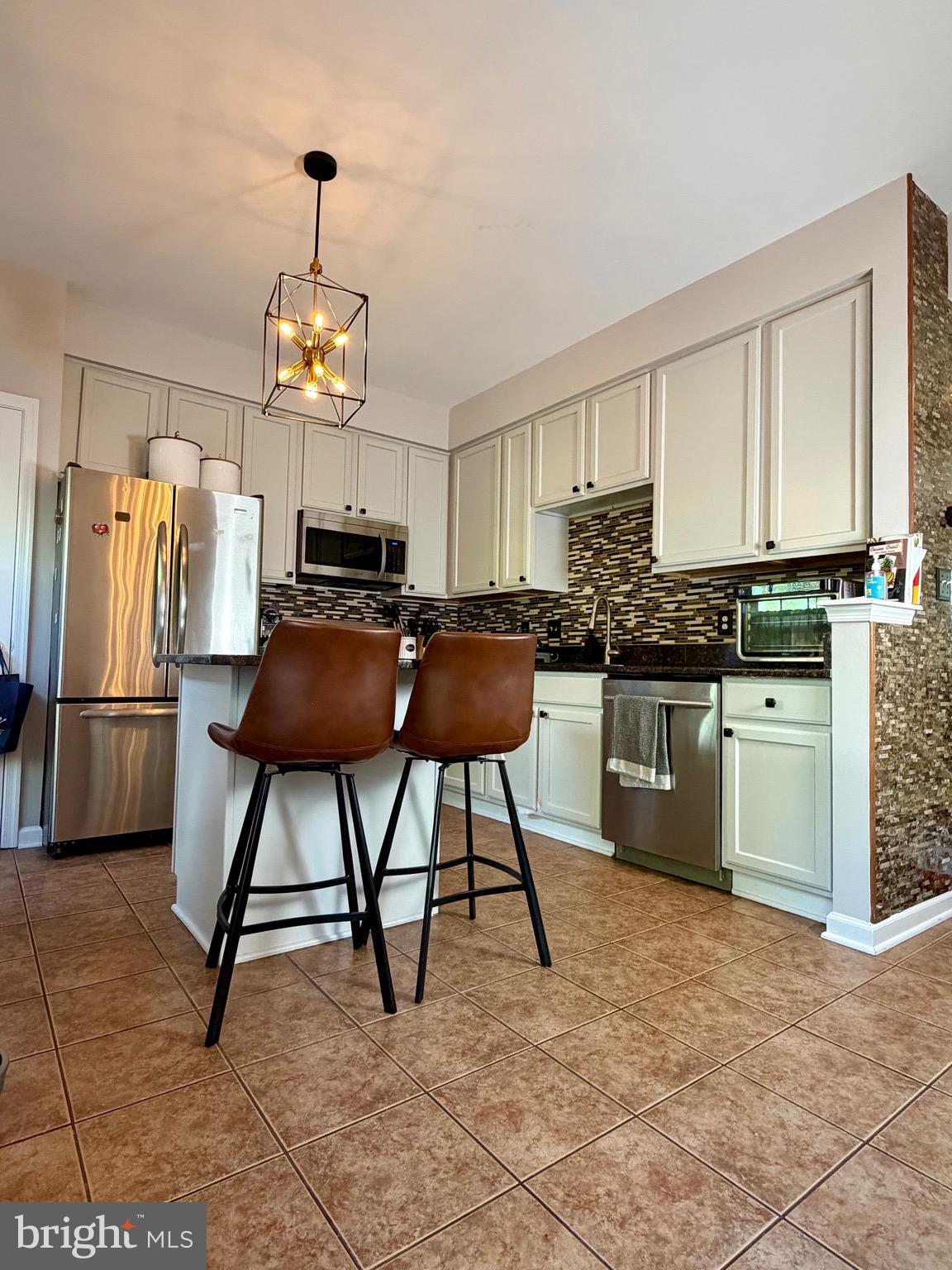 7108 Wheeling Way Gainesville, VA 20155 - Photo 10 of 45 a kitchen with stainless steel appliances granite countertop a stove a sink dishwasher a refrigerator and a dining table with wooden cabinet