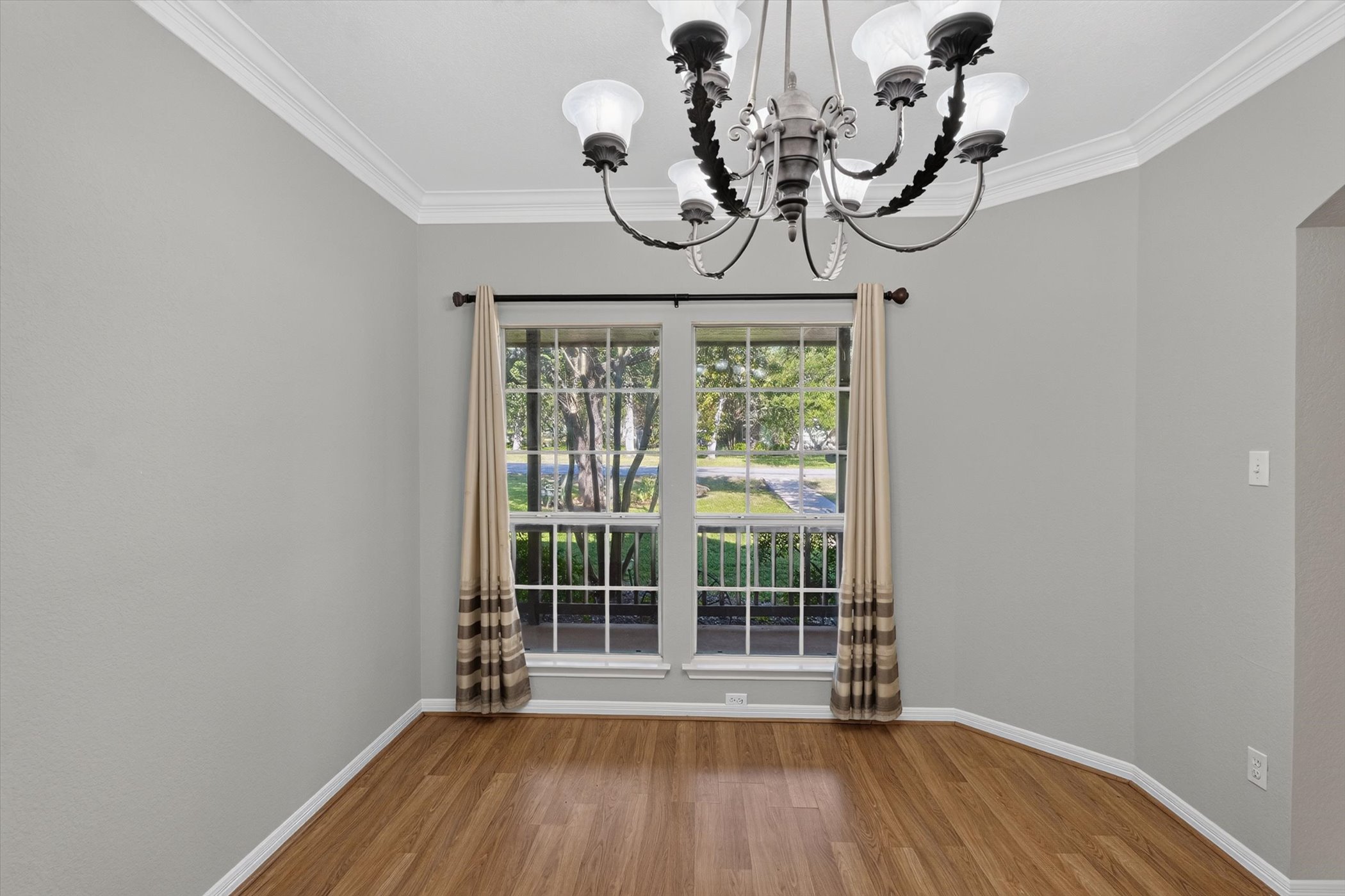 13615 Copperleaf Trail Manchaca, TX 78652 - Photo 12 of 38 A graceful chandelier illuminates this versatile space, featuring rich hardwood floors and crown molding.
