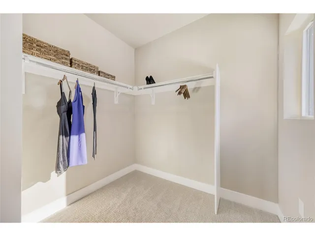 a view of walk in closet with clothes