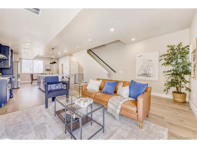 a living room with furniture and a dining table with wooden floor