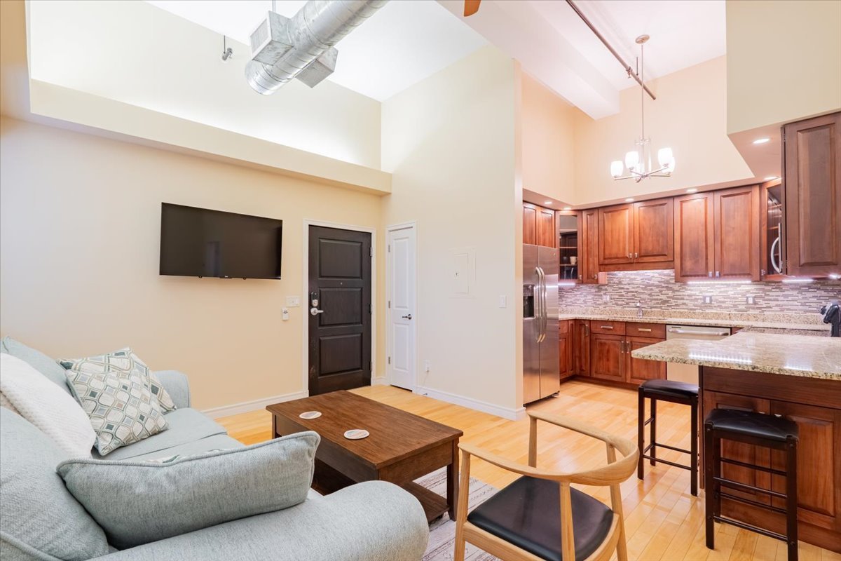 212 North Center Street, Unit 104 Bloomington, IL 61701 - Photo 2 of 22 a living room with furniture and a flat screen tv