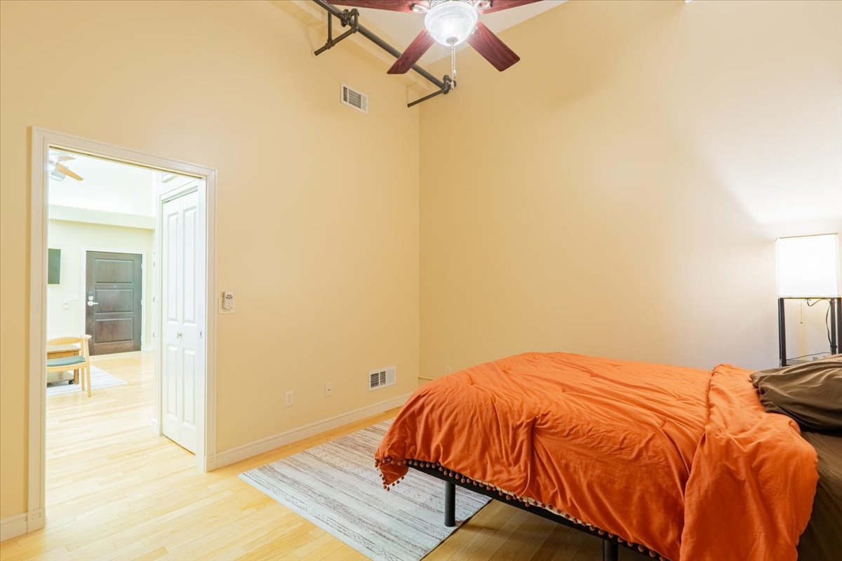 212 North Center Street, Unit 104 Bloomington, IL 61701 - Photo 8 of 22 a bedroom with a bed and wooden floor
