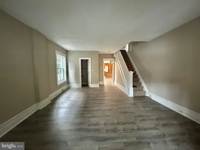 a view of a livingroom with wooden floor and stairs