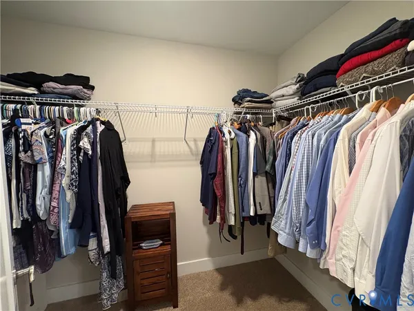 a view of walk in closet with clothes and shoes