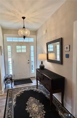 a view of a livingroom with furniture wooden floor chandelier and a rug