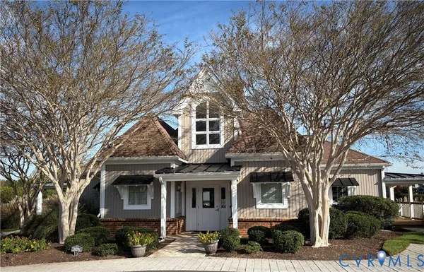 a front view of a building with large trees