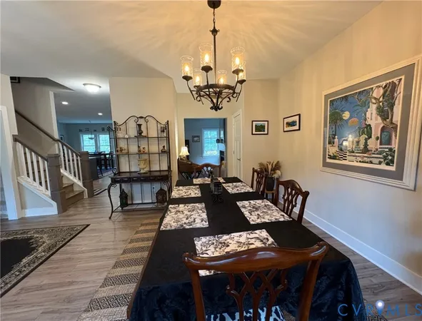 a living room with furniture a chandelier and a dining table