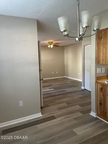 a view of a hallway with wooden floor and a room