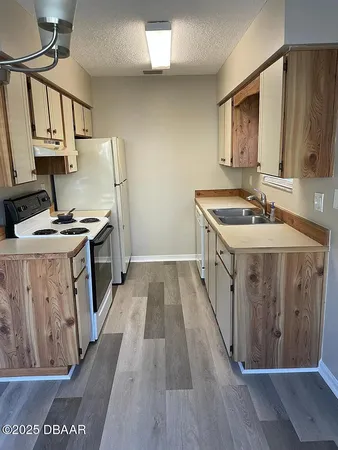 a kitchen with sink stove and wooden cabinets
