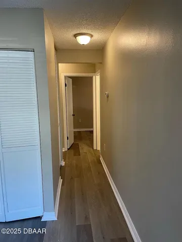 a view of a hallway with wooden floor